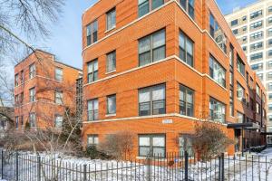 a red brick building with a fence in front of it at Apartment by the lake in Chicago