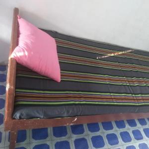 uma cama com uma almofada cor-de-rosa em cima em Nithusha holiday house நிதுஷா சுற்றுலா விடுதி em Jaffna