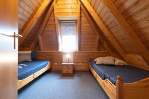 a bedroom with two beds in a wooden cabin at LA 26 - Strandvogt 3 Komfort in Schottwarden