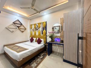 Hotel Jai Balaji Near New Delhi Railway Station في نيودلهي: غرفة نوم بسرير ومكتب ومرآة