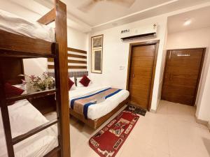 a bedroom with two bunk beds and a bathroom at Hotel Jai Balaji Near New Delhi Railway Station in New Delhi