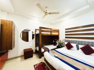 Hotel Jai Balaji Near New Delhi Railway Station في نيودلهي: غرفة نوم مع سريرين بطابقين ومرآة
