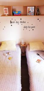 dwa łóżka siedzące obok siebie w pokoju w obiekcie MH camping 4 étoile Mer/forêt w mieście Soulac-sur-Mer