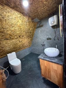 a bathroom with a white toilet and a sink at Ikshana Cottages in Kalasa