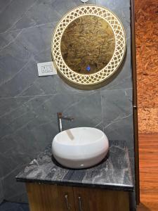 a bathroom with a sink and a mirror on a counter at Ikshana Cottages in Kalasa