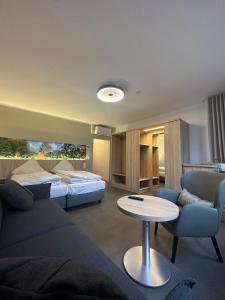 ein Hotelzimmer mit einem Bett, einem Sofa und einem Tisch in der Unterkunft MediTerra in Papenburg