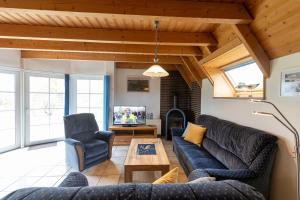 a living room with a couch and chairs and a tv at LA 26 - Strandvogt 3 Komfort in Schottwarden