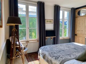 - une chambre avec un lit et de grandes fenêtres dans l'établissement Côté Baie, à Saint-Valery-sur-Somme