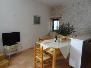 ein Esszimmer mit einem weißen Tisch und einem TV in der Unterkunft Le Cantine in Vacone