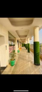 un edificio con columnas verdes y plantas en un pasillo en SN hotel inn and restaurant, en Sikandarābād