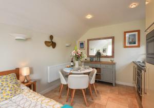 a bedroom with a bed and a table and chairs at Y Ddol Bach in Abersoch