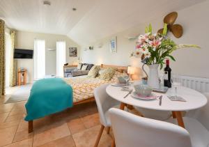 a living room with a couch and a table with flowers at Y Ddol Bach in Abersoch