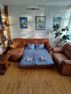 a living room with a leather couch and a bed at Spacious apartment near old town in Vilnius