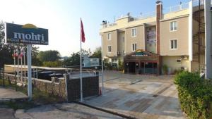 a hotel with a sign in front of a building at Karamürsel Mohti Otel Fitness Organizasyon in Karamusal