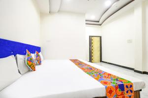 a bedroom with a bed with a colorful blanket on it at FabExpress High Star in Ujjain
