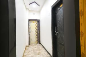 a hallway with a black door and a tile floor at FabExpress High Star in Ujjain