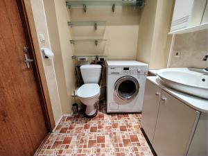 a bathroom with a toilet and a washing machine at Spacious apartment near old town in Vilnius