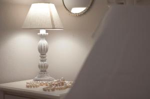 une lampe posée sur une table avec des perles dessus dans l'établissement Le case del Duca, à Ioppolo Giancaxio