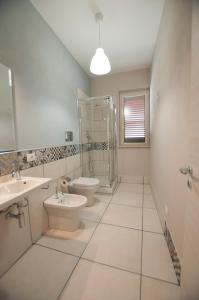 La salle de bains est pourvue de 2 lavabos, de toilettes et d'une douche. dans l'établissement Le case del Duca, à Ioppolo Giancaxio
