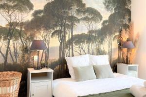 1 dormitorio con un mural de árboles en la pared en L'Amazone-Appart au calme avec balcon et parking, en Nantes