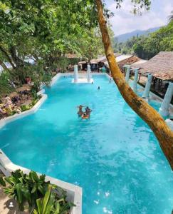 a pool at a resort with people swimming in it at LaGita Carita Villa in Pandegelang