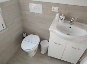 uma casa de banho branca com um WC e um lavatório em Le Dimore degli Artisti em Venosa