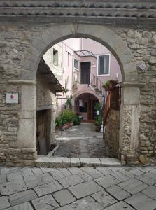 um arco num edifício de pedra com um beco em Le Dimore degli Artisti em Venosa