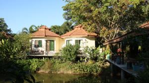 a house with a river in front of it at Navari Homestay in Rayong