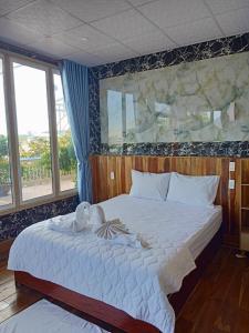 a bedroom with a large white bed with a large window at Sông Hotel PQ - by BAY LUXURY in Phu Quoc