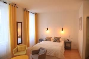 - une chambre avec un lit et deux chaises dans l'établissement Maison Candela, à Argelès-Gazost