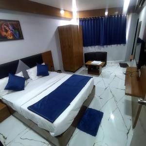 a bedroom with a large bed with blue pillows at HOTEL SHREE RADHE in Ahmedabad