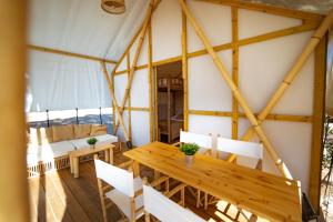 a room with a wooden table and chairs in a tent at Kampaoh Costa Dorada in Creixell