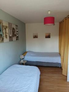 1 dormitorio con 2 camas y luz roja en Au fil de l'eau, en Conchy-sur-Canche