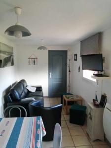 uma sala de estar com um sofá e uma televisão em Au fil de l'eau em Conchy-sur-Canche