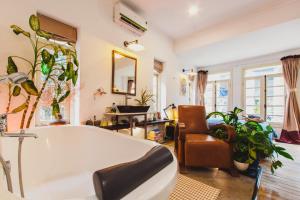 a bathroom with a large white tub and a chair at Bunker - The Suite in Ho Chi Minh City