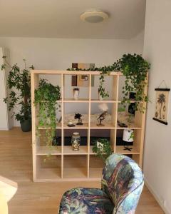 a living room with a book shelf with plants at Cozy and bright apartment in Viby