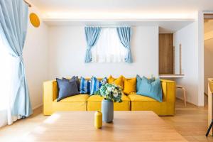 sala de estar con sofá amarillo y almohadas azules en Modern House Tokyo east, en Tokio