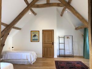a bedroom with white walls and wooden beams at Chateau de Tosny in Tosny