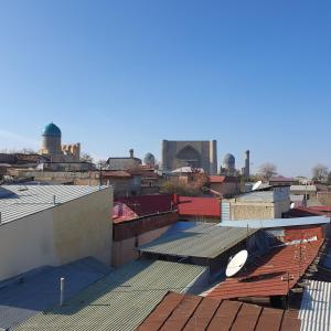 una vista de los tejados de una ciudad con una mezquita en The Afrosiyob Ok, en Samarkand