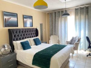 a bedroom with a large bed with blue pillows at Hatfield, Grosvenor Private apartment. in Pretoria