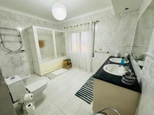 a white bathroom with a sink and a toilet at DMCharme in Ponta Delgada