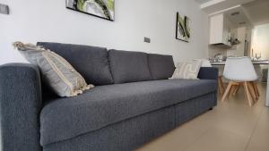 a blue couch with pillows on it in a living room at MIRADOR Poniente beach apartments in Benidorm