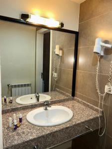 a bathroom with a sink and a large mirror at Iris Flower Hotel in Jezz&icirc;ne