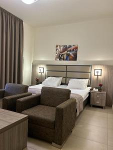 a hotel room with a bed and a couch at Iris Flower Hotel in Jezz&icirc;ne