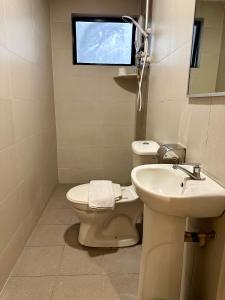 uma casa de banho com um WC e um lavatório em Swing & Pillows - KL Pekeliling formerly known as Swiss Cottage Hotel em Kuala Lumpur