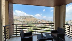 a balcony with a view of a city at Iris Flower Hotel in Jezzîne