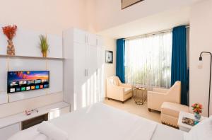 1 dormitorio con 1 cama, TV y sillas en YO's Homes Rivergate Apartment Infinity Pool Near District 1, en Ho Chi Minh