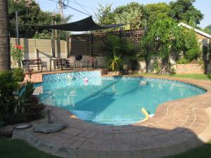 a swimming pool in a yard with a patio at Zebra Appartment in Witbank