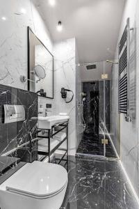 La salle de bains en noir et blanc est pourvue de toilettes et d'une douche. dans l'établissement Equides club, à Lesniki