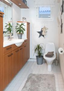 uma casa de banho com lavatório, WC e duas plantas em Arctic Circle Home close to Santa`s Village em Rovaniemi